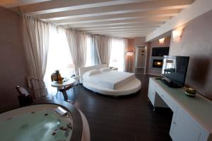 Hotel Morgana في Rodengo Saiano: حمام مع سرير وحوض استحمام في الغرفة