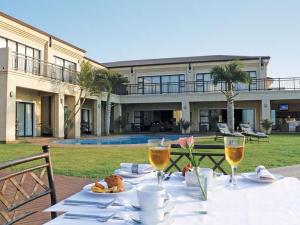 a table with plates of food and glasses of wine at Fairway Guest House in Durban