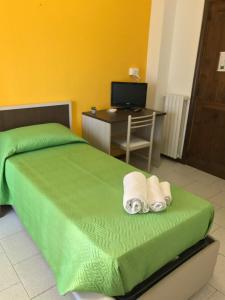 - une chambre avec un lit vert, un bureau et un ordinateur dans l'établissement Hotel Marina, à Badesi