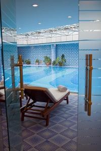 a swimming pool with a chair in front of a pool at Golden Coast in Baku