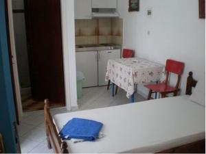 a kitchen with a table and two chairs and a table at Artemis Pension in Ios Chora
