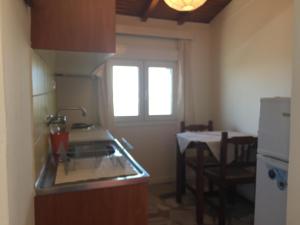 een keuken met een wastafel, een tafel en een raam bij Popy Apartments in Ierápetra