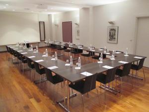 une grande salle de conférence avec une grande table et des chaises dans l'établissement arte Hotel Linz, à Linz