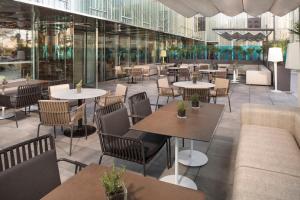 a restaurant with tables and chairs in a building at Melia Barcelona Sky 4* Sup in Barcelona