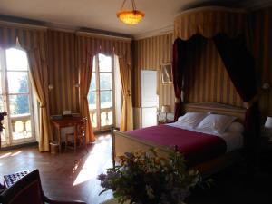 - une chambre avec un grand lit à baldaquin dans l'établissement Le Château d'Ailly, à Parigny