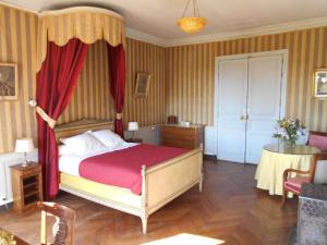 Schlafzimmer mit einem Bett mit rotem Baldachin in der Unterkunft Le Château d'Ailly in Parigny