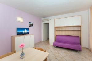 a living room with a purple couch and a table at Residence Riva Blu in Cesenatico