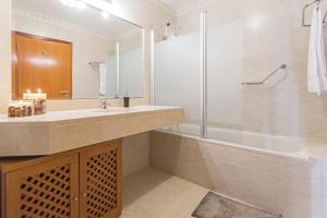 Un baño con bañera, lavabo y ducha. en Ajuda II by An Island Apart, en Funchal 14 fotos más