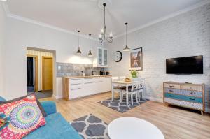 a living room with a blue couch and a kitchen at Right Stay in Gdańsk