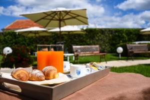 una bandeja de pan y zumo de naranja en una mesa en Hotel d'Altavilla, en Canosa di Puglia