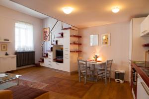 a kitchen and living room with a table and chairs at Rimska Apartments Tour As Ljubljana in Ljubljana