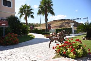 a park with benches and flowers and palm trees at Hotel d'Altavilla in Canosa di Puglia