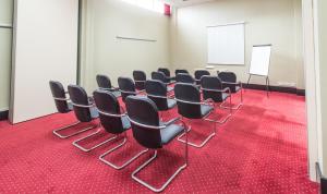 a conference room with black chairs and a whiteboard at Sheffield Metropolitan Hotel in Sheffield