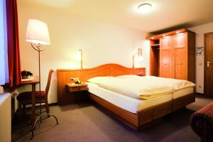 a bedroom with a bed and a table and a lamp at Gästehaus Korf in Unkel