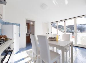 een witte keuken met een witte tafel en stoelen bij Tetto Bianco in Massa Lubrense
