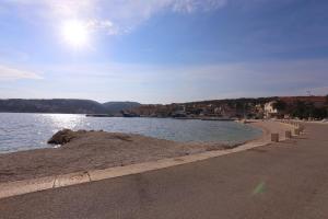 a sandy beach next to a body of water at Apartman Vrsalović in Sumartin