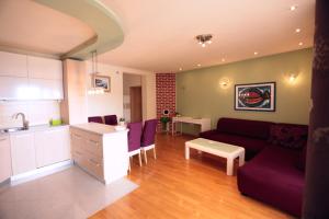 a living room with a couch and a kitchen at Apartman Vrsalović in Sumartin