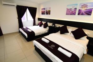 a hotel room with two beds and a window at Hotel Lavender Senawang in Seremban