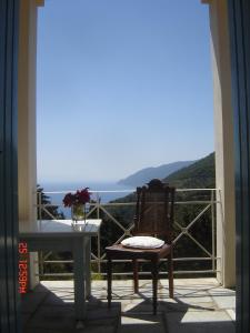 una silla y una mesa en un balcón con vistas en Villa Frederike in Alonissos Old Town en Alonnisos Old Town