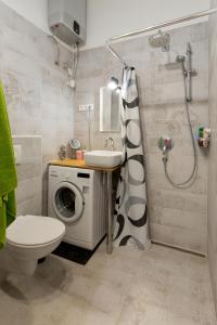 bagno con lavandino e servizi igienici e lavatrice. di F4 Fiumei Apartment a Budapest