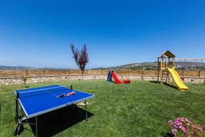 a blue ping pong table in a yard with a playground at Renta Villas, vivid experience, By ThinkVilla in Perama
