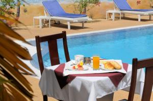 una mesa con un plato de comida junto a una piscina en Residence Eburnea en Abiyán