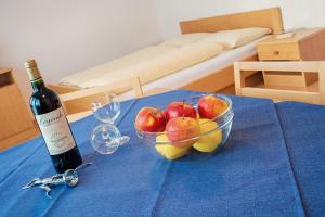 un tazón de manzanas y una botella de vino en una mesa en Residence Ledi, en San Valentino alla Muta