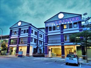 un coche aparcado en un estacionamiento frente a un hotel lavanda en Hotel Lavender Senawang, en Seremban