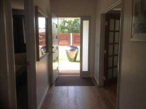 a hallway with a door leading to a yard at Carpe Diem South in Busselton