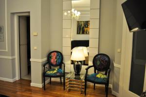 a living room with two chairs and a table with a lamp at Andromeda Hotel Thessaloniki in Thessaloniki