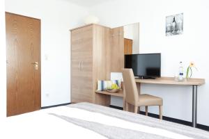 a room with a desk with a computer and a chair at Hotel zwei&vierzig in Koblenz