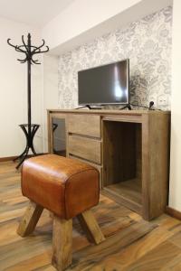 a room with a desk with a television and a stool at Penzión Ulička in Stupava