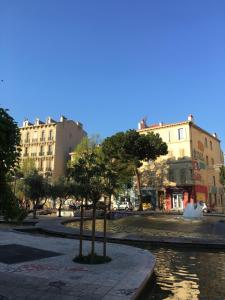 un árbol en medio de una calle con edificios en Le Studio des Artistes, en Marsella