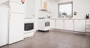 uma cozinha branca com electrodomésticos brancos e uma janela em Thommysminde em Jelling