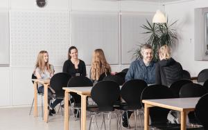 um grupo de pessoas sentadas em mesas em uma sala em Thommysminde em Jelling