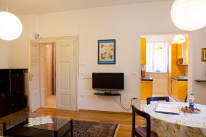 a living room with a table and a television at Rimska Apartments Tour As Ljubljana in Ljubljana