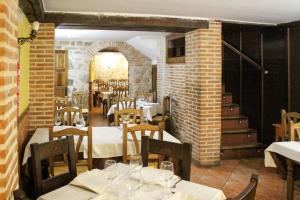 een restaurant met tafels en stoelen en een bakstenen muur bij San Miguel in Segovia