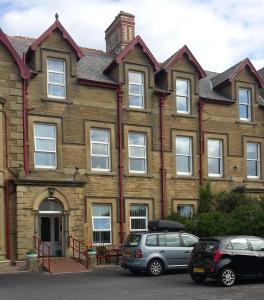 uma casa com carros estacionados em frente em Manhattan Lodge em Lytham St Annes