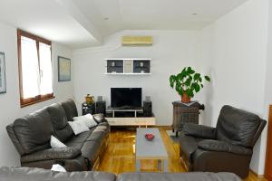 a living room with two couches and a tv at Apartment Juras in Opatija