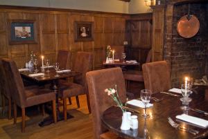 a restaurant with wooden walls and tables and chairs at White Hart Hotel in St. Albans