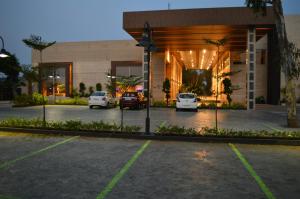 a parking lot in front of a building with cars parked at Welcomhotel by ITC Hotels, Kences Palm Beach, Mamallapuram in Mahabalipuram
