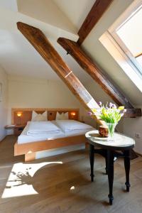 a bedroom with a bed and a table with flowers on it at Boutique-garni Hotel Papillon in Kempen