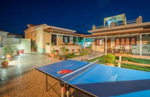 una mesa de ping pong en el patio trasero de una casa en Fiorentinos Villa, en Tragaki