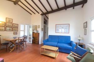 een woonkamer met een blauwe bank en een tafel bij Casa Marchini - Goelba in Portoferraio
