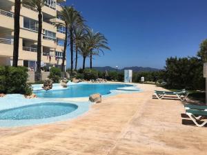 ein großer Pool mit Stühlen und ein Gebäude in der Unterkunft Family Sun Seasight Apartment in Cala Millor