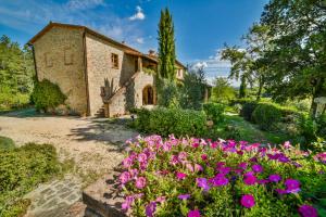 a garden with flowers in front of a house at Podere Casanuova in San Gimignano