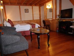 a living room with a bed and a coffee table at 清境豐田桂林山莊民宿 in Ren'ai