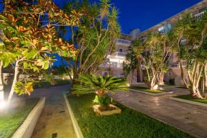 an exterior view of a building with palm trees at Zakynthos Hotel in Tsilivi