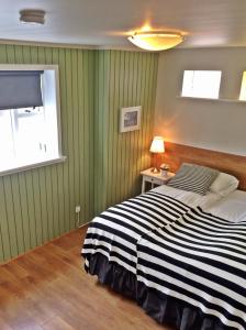 a bedroom with a bed with a black and white striped blanket at Thoristun Apartments in Selfoss