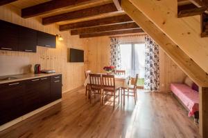 a kitchen and dining room with a table and a bedroom at Ośrodek Wczasowy Maliwa in Jarosławiec